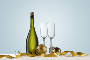 Image showing Glasses with champagne and bottle over sparkling holiday background