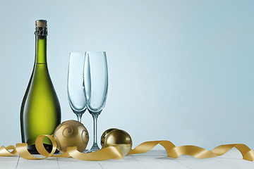 Image showing Glasses with champagne and bottle over sparkling holiday background