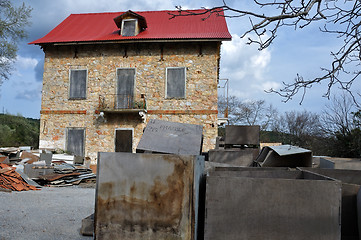 Image showing derelict stone house and pile of box crates