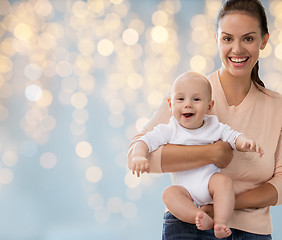 Image showing happy mother with little baby boy over lights