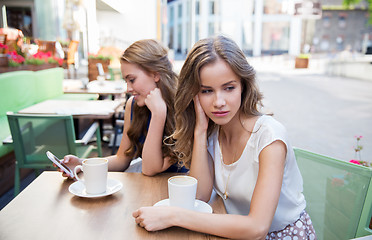 Image showing young women with smartphone and coffee at cafe