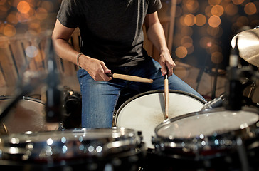 Image showing musician playing drum kit at concert over lights