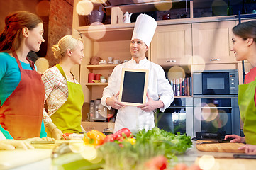 Image showing happy women and chef cook with menu in kitchen