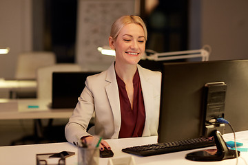 Image showing businesswoman at computer working at night office