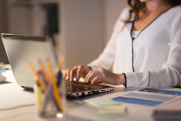 Image showing businesswoman with laptop working at night office