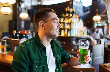 Image showing man drinking green beer at bar or pub