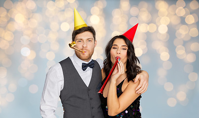 Image showing happy couple with party blowers having fun