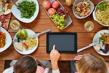 Image showing women with tablet pc at table full of food