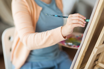 Image showing artist with brush painting at art studio