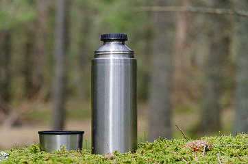 Image showing Thermos and cup on a mossy ground