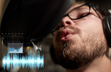 Image showing man with headphones singing at recording studio