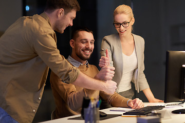 Image showing business team making thumbs up gesture at office