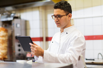 Image showing chef cook with tablet pc at restaurant kitchen