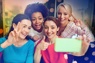 Image showing happy young women taking selfie with smartphone