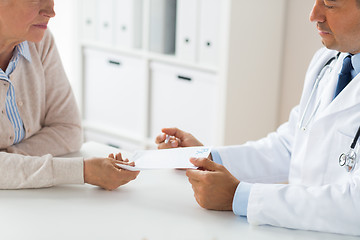 Image showing woman and doctor with prescription at clinic