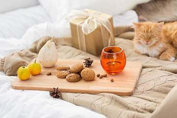 Image showing oatmeal cookies, christmas gift and candle in bed