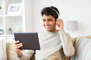 Image showing man in phones with tablet pc listening to music