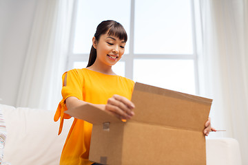 Image showing happy asian young woman with parcel box at home