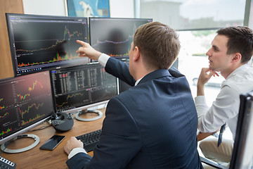 Image showing Stock brokers looking at computer screens, trading online.