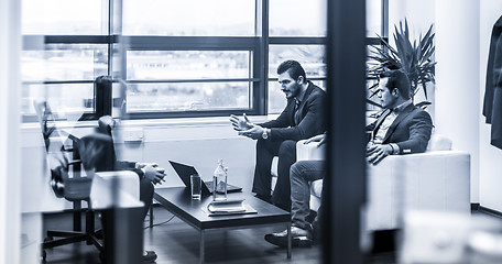 Image showing Businessmen interviewing female candidate for job in modern corporate office.