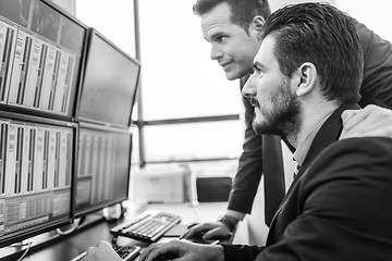 Image showing Stock traders looking at market data on computer screens.