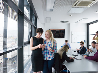 Image showing Two Elegant Women Using Mobile Phone by window in office buildin