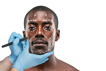 Image showing Surgeon drawing marks on male face against gray background. Plastic surgery concept