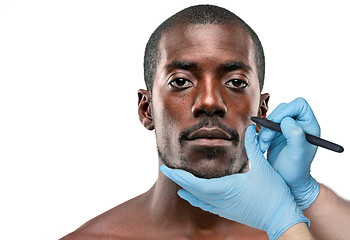 Image showing Surgeon drawing marks on male face against gray background. Plastic surgery concept