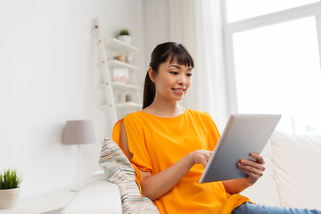 Image showing happy young asian woman with tablet pc at home