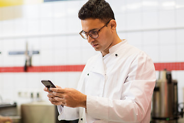 Image showing chef cook with smartphone at restaurant kitchen