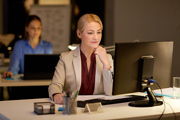 Image showing businesswoman at computer working at night office