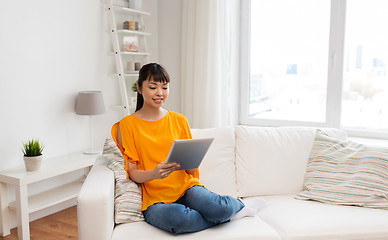 Image showing happy young asian woman with tablet pc at home