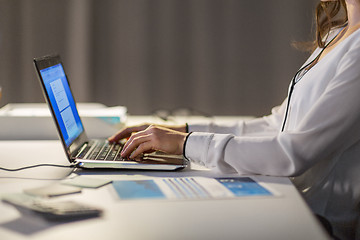 Image showing businesswoman with laptop working at night office