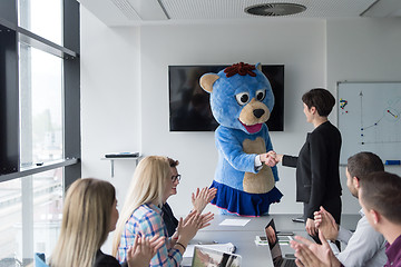 Image showing boss dresed as bear having fun with business people in trendy of