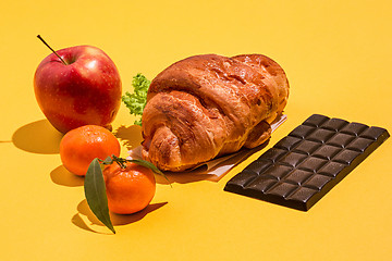 Image showing The apple, chocolate and croissants on yellow background