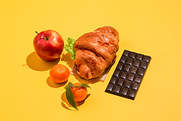 Image showing The apple, chocolate and croissants on yellow background