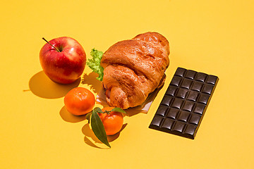 Image showing The apple, chocolate and croissants on yellow background