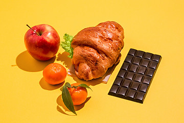 Image showing The apple, chocolate and croissants on yellow background