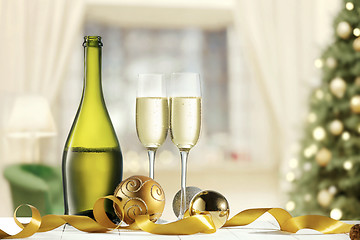Image showing Glasses with champagne and bottle over sparkling holiday background