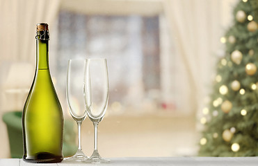 Image showing Glasses with champagne and bottle over sparkling holiday background