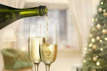 Image showing Glasses with champagne and bottle over sparkling holiday background