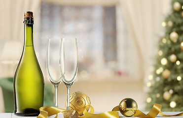 Image showing Glasses with champagne and bottle over sparkling holiday background