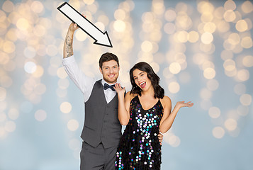 Image showing happy couple with big arrow at party