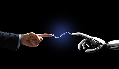 Image showing robot and human hand connected by lightning