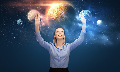 Image showing happy businesswoman with virtual planets and space