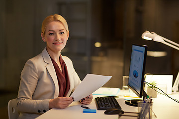 Image showing businesswoman with papers working at night office