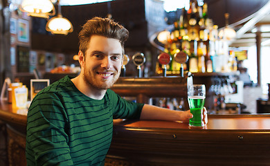 Image showing man drinking green beer at bar or pub