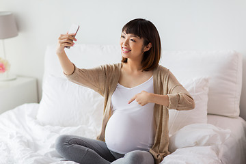 Image showing pregnant woman taking selfie by smartphone at home