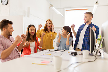 Image showing happy creative team celebrating success at office