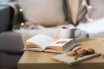 Image showing book with autumn leaf, cookies and tea on table